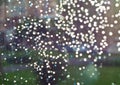 Drops on the window glass. Blurred background of street rain in the rays of the bright sun Royalty Free Stock Photo