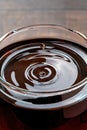 Drops of wine and waves forming in a glass full of red wine standing on a wooden table Royalty Free Stock Photo