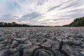 Drought and climate change, landscape of cracked earth with orange sky after lake has dried up in summer. Water crisis an impact Royalty Free Stock Photo