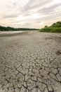 Drought and climate change, landscape of cracked earth with orange sky after lake has dried up in summer. Water crisis an impact Royalty Free Stock Photo