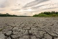 Drought and climate change, landscape of cracked earth with orange sky after lake has dried up in summer. Water crisis an impact Royalty Free Stock Photo