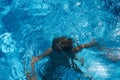 Drowning kid into swimming pool water. Boy