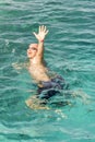 Drowning man in sea asking for help with raised arms. The man is drowning in the sea. vertical photo