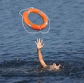 Drowning woman with raised hand getting lifebelt in sea, closeup Royalty Free Stock Photo