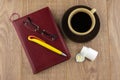 Drowsiness : caffeine pills near the pill box, diary, glasses and mug of strong coffee on the wooden table, yellow ball-point pen