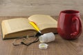 Drowsiness : caffeine pills near the pill box, old book, glasses, and a red mug of strong coffee on the wooden table, yellow ball-