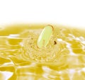 Drug yellow capsule fish oil omega3 droping in oil water on whi Royalty Free Stock Photo