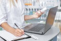 Druggist making notes from the laptop Royalty Free Stock Photo