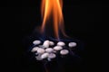 Drugs on fire on a black background. Stop addiction concept. Drug burning