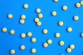 The texture of many yellow pills lie on a white background. Royalty Free Stock Photo