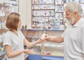 Drugstore consultant helping old pensioner with medicines.