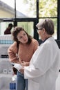 Drugstore worker helping sick adult client with abdominal cramps offering stomachache medication