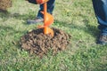 Excavator machine digging hole into grass