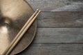 Drum stick and crash cymbal on wood table background