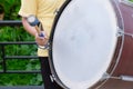 Drum sticks hitting the drum. The drummer is drumming bass drum in a marching band in the parade.