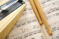 Drum sticks and metronome on music score Royalty Free Stock Photo