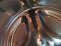 The drum of the washing machine from the inside. Shiny metal tank with holes and bulges. Stainless steel surface with holes, made