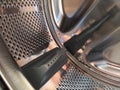 The drum of the washing machine from the inside. Shiny metal tank with holes and bulges. Stainless steel surface with holes