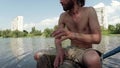 Drummer hands playing on a makeshift drum on a background of lake and building, drum sets, pulling ropes, lake, willow branches