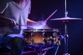 A drummer plays drums on a blue background. Beautiful special effects of light and smoke Royalty Free Stock Photo