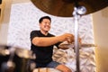 a drummer smiles while preparing hi-hat cymbals before being used