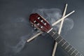 Drumsticks and guitar fretboard in smoke close up. acoustic musical instrument. copy space