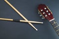 Drumsticks and guitar headstock close up. acoustic musical instrument