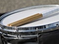 Drumsticks on snare drum in parking lot during marching band practice