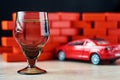 Drunk driving car crash accident. Don`t drive after drink concept. Shot glass and a broken car Royalty Free Stock Photo