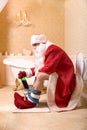 Drunk Father Christmas sitting on the toilet