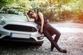 Drunk girl stands next to her car with bottle alcohol in her hands Royalty Free Stock Photo