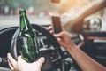 Drunk man driving a car on the road holding bottle beer Dangerous drunk driving concept Royalty Free Stock Photo