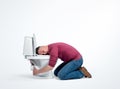 Drunk man sleeping on the toilet hugging him, on a light background. Royalty Free Stock Photo