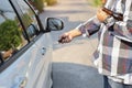 Drunk man try opening vehicle with car key while holding alcohol bottle in another hand drink not drive concept Royalty Free Stock Photo