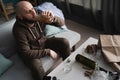 Drunk middle adult man at home on couch drinking whiskey from bottle in alcoholism problem, alcohol abuse and addiction