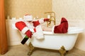 Drunk Santa Claus with bottle sleeping in a bath