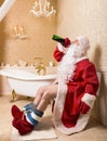 Drunk Santa Claus sitting on the toilet