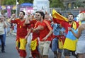 Drunk soccer Spanish fans wearing red T-shirt, faces painted in national colors, cheering for his football team on the street
