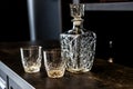 Drunk whiskey in crystal glasses. empty bottle and glasses for drinks on a dark wooden table. containers for alcoholic beverages