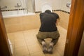 Drunk Young Man Vomiting in the Toilet at Home