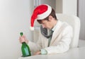 Drunken man in Christmas cap with bottle in a hand