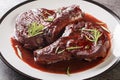 Drunken Pork Chops with red wine sauce and herbs closeup on the plate. Horizontal Royalty Free Stock Photo