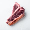 Dry-aged Raw T-bone or porterhouse beef marbled meat prime steak, on white stone background, square format