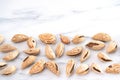 Dry almonds in golden shells are scattered on a white table. Healthy food high in protein, omega-3s, antioxidants and vitamins.