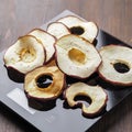 Dry apples circle form on glass electronic weigh-scale on brown wooden background Royalty Free Stock Photo