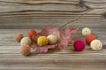 Dry autumn maple leaf on wooden background. Herbarium. Artistic original backdrop. Handmade crochet beads, knitting, sewing