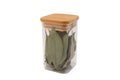 Dry bay leaf in glass jar isolated on a white background. Green bay leaf. Aroma ingredient. Natural healthy food and diet