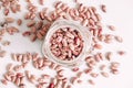 Dry beans in a glass jar scattered on a white table background. Top view. Copy, empty space for text Royalty Free Stock Photo