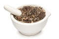 Closeup of Dry Bhringraj leaves, in white ceramic mortar and pestle.