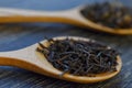 dry black tea leaves on a wooden spoon on a dark background macro close-up Royalty Free Stock Photo